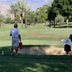 The Golf Center At Palm Desert - Daughter practicing sand shots with dad ready to retrieve balls.