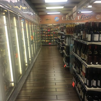 Beer Stop - a row of wine bottles in a store - Beer Gardens Near Me - Tallahassee, Florida