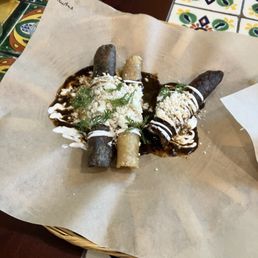 Taquitos de papa (crunchy potato) con mole. Delicious.