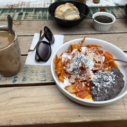 Palreal - Cafe Americano, chilaquiles rojos with black beans, and bread with a salsa spread.