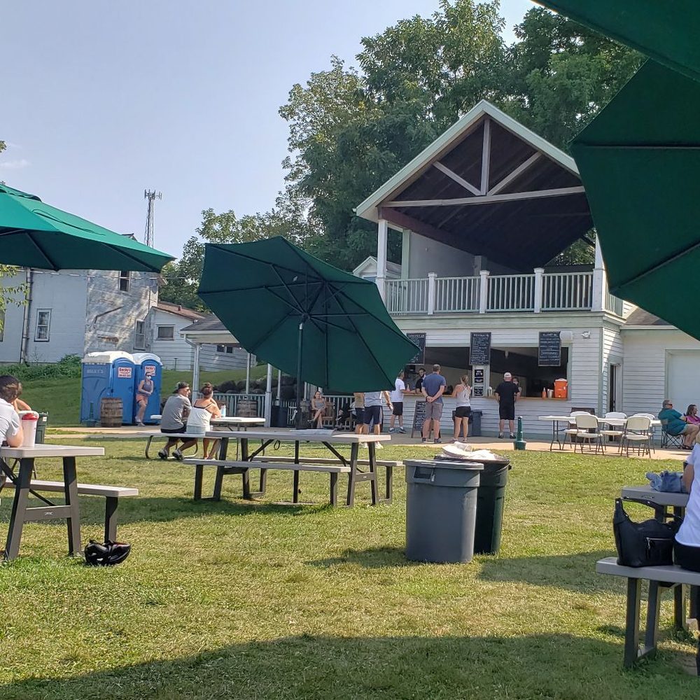 Riley Tavern - people sitting at picnic tables under umbrellas - Bars Near Me - Verona, Wisconsin