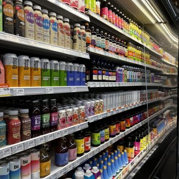 Natural Grocers - a variety of products in a store - Store shelves in Natural Grocers in Albuquerque, NM, are filled with a variety of bottled health drinks, probiotic supplements, and wellness products. The products are organized in rows with different brands and flavors, including kombucha, herbal tonics, and probiotic drinks. The shelves are well-stocked, and the store lighting illuminates the products clearly. The image captures the retail environment focused on health and wellness offerings. - Grocery Near Me - Albuquerque, New Mexico