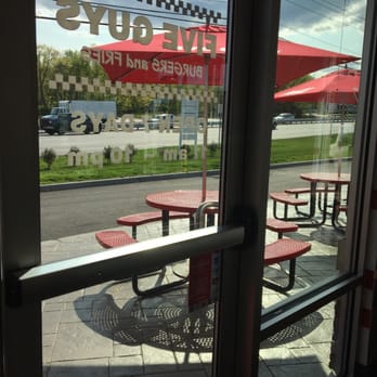 Five Guys - the outside of a restaurant with tables and umbrellas - Fast Food Near Me - Sutton, Massachusetts