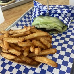Lettuce wrap burger mushroom and Swiss with a side of fries . Lettuce wrap burger mushroom and Swiss with a side of fries .