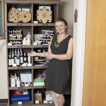 Healing Solutions - Owner and Founder Suzette Skidmore standing in front of oils and lotion products, available in-store and online through our website. - Massage Therapy Near Me - Broomfield, Colorado Healing Solutions - Owner and Founder Suzette Skidmore standing in front of oils and lotion products, available in-store and online through our website. - Massage Therapy Near Me - Broomfield, Colorado