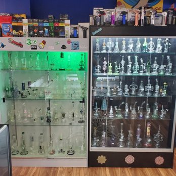 Smokers Cabinet - More pipes hanging out in the back of the shop. Hookahs, hookah supplies, and torches reside here too. - Vape Shops Near Me - Spartanburg, South Carolina Smokers Cabinet - More pipes hanging out in the back of the shop. Hookahs, hookah supplies, and torches reside here too. - Vape Shops Near Me - Spartanburg, South Carolina