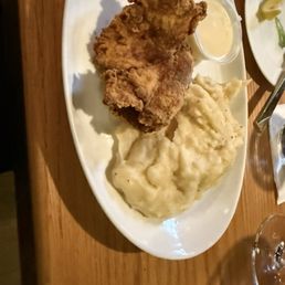 A thin piece of overcooked, chicken and potatoes A thin piece of overcooked, chicken and potatoes