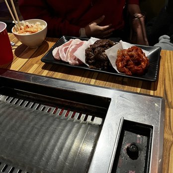 One Pocha - a table with a grill and bowls of food - Korean Near Me - San Antonio, Texas One Pocha - a table with a grill and bowls of food - Korean Near Me - San Antonio, Texas