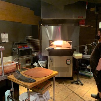 Tessio - a woman standing in a kitchen with a pizza oven - Pizza Near Me - Silverdale, Washington Tessio - a woman standing in a kitchen with a pizza oven - Pizza Near Me - Silverdale, Washington