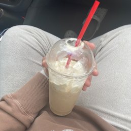 a person holding a drink in their lap a person holding a drink in their lap