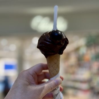 Venchi - a hand holding a chocolate ice cream cone - Chocolatiers & Shops Near Me - McLean, Virginia