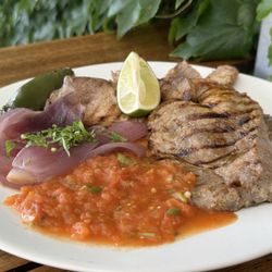 A Yucatán classic of citrus-marinated grilled pork, seasoned with garlic, black pepper, and salt, then served with a Tatemada salsa