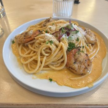 Nafsi - Shrimp Bucatini - A dish of shrimp bucatini pasta served with a creamy sauce, topped with herbs, cheese, and microgreens, on a white plate. - New American Near Me - Chicago, Illinois
