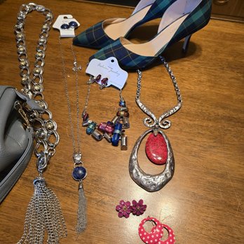 Fairhaven Thrift Store - Jewelry and shoes I purchased. - Jewelry including necklaces, earrings, and bracelets, along with a pair of plaid high heels, are arranged on a wooden table. - Thrift Stores Near Me - Covington, Kentucky