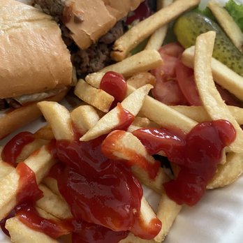 Double T Diner - Philly Steak and Cheese Sub with fries - French fries with ketchup, a cheeseburger sub, and pickles are shown on a plate, served with a side salad. - Diners Near Me - Laurel, Maryland