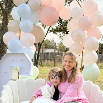 The Playwell Club - A sweet moment of a mom and child sitting together on a soft white couch, framed by pastel balloons in a calm outdoor setting. - Venues & Event Spaces Near Me - Round Rock, Texas The Playwell Club - A sweet moment of a mom and child sitting together on a soft white couch, framed by pastel balloons in a calm outdoor setting. - Venues & Event Spaces Near Me - Round Rock, Texas