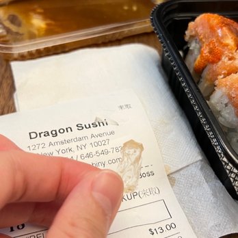 Dragon Sushi - a hand holding a piece of food - Japanese Near Me - New York, New York