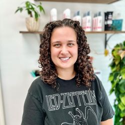 Medium length curly haircut and style with a little volume and body
