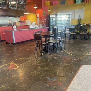 La Zenita - Decor - A Mexican eatery features a seating area with tables and chairs, colorful papel picado banners, and a counter with a menu board. - Mexican Near Me - Albuquerque, New Mexico