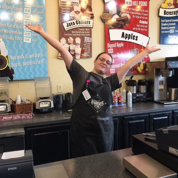 Fudgery - a woman standing behind a counter with her arms in the air - Candy Stores Near Me - Sevierville, Tennessee