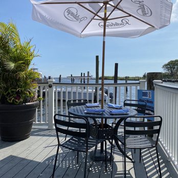 Drift 82 - a table and chairs on a deck overlooking the water - New American Near Me - Patchogue, New York Drift 82 - a table and chairs on a deck overlooking the water - New American Near Me - Patchogue, New York