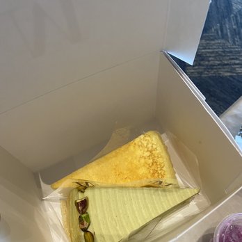 Lady M Cake Boutique - The cakes. Signature Crepe Cake on the left, pistachio crepe cake on the right. Recommend the signature. - Bakeries Near Me - Tysons, Virginia Lady M Cake Boutique - The cakes. Signature Crepe Cake on the left, pistachio crepe cake on the right. Recommend the signature. - Bakeries Near Me - Tysons, Virginia