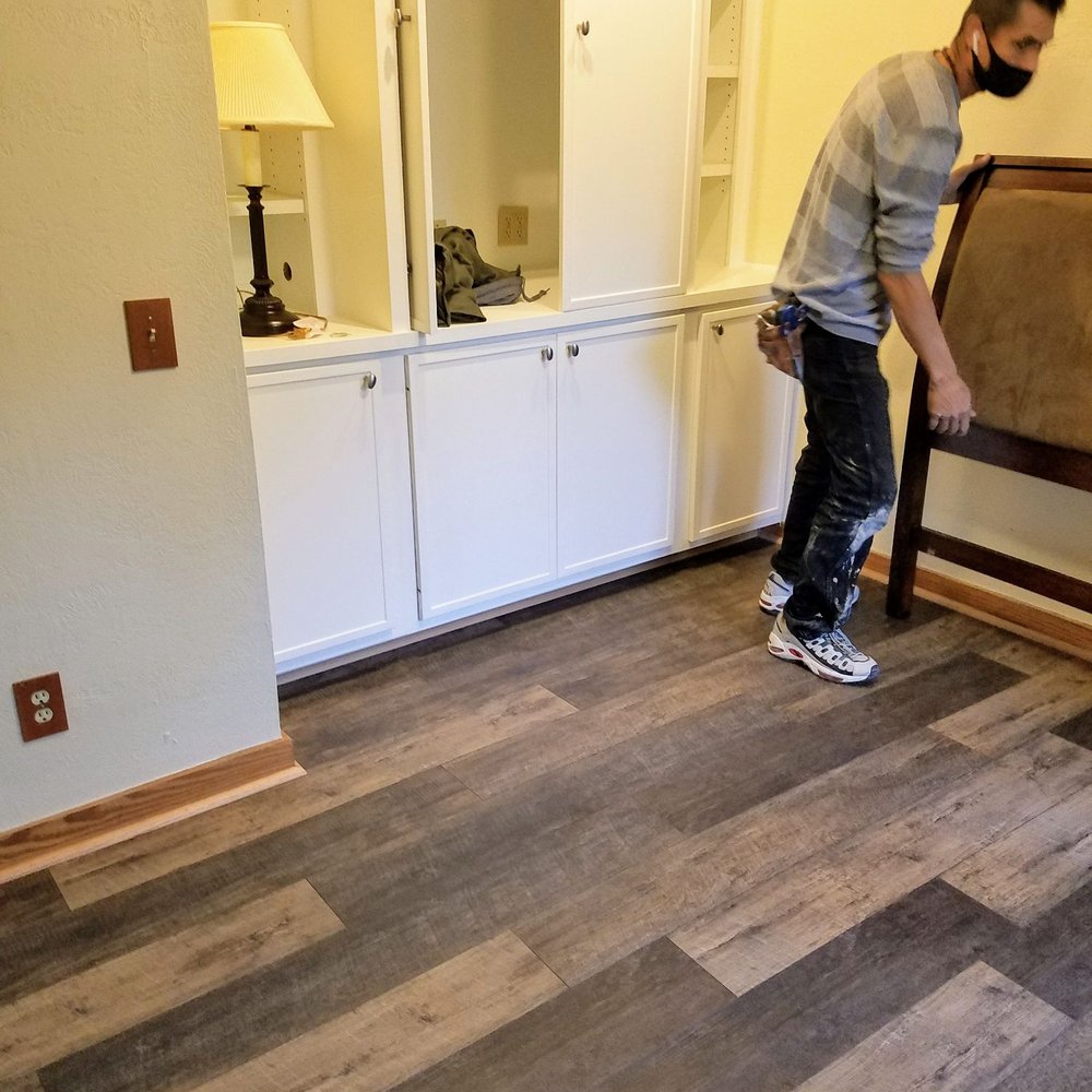 Butler Floors - a man moving a bed in a living room - Carpeting Near Me - Austin, Texas Butler Floors - a man moving a bed in a living room - Carpeting Near Me - Austin, Texas