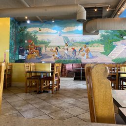 a restaurant with a mural on the wall a restaurant with a mural on the wall