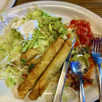 Los Molcajetes - 2 of the 4 flautas with guacamole and sour cream. - Mexican Near Me - Fort Worth, Texas