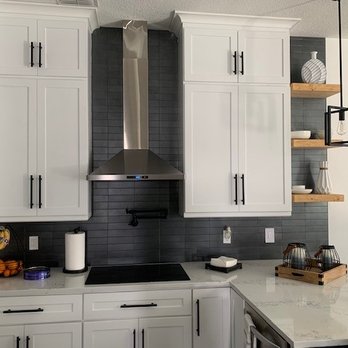 Dimension Flooring Services - a kitchen with white cabinets and a stainless steel range hood - Flooring Near Me Dimension Flooring Services - a kitchen with white cabinets and a stainless steel range hood - Flooring Near Me