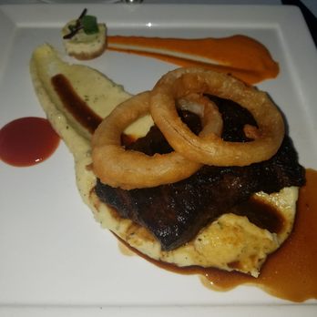 Latitudes - Sunset Key Cottages - Flank steak over mashed potatoes with onion rings and a small goat cheese cake - Seafood Near Me - Key West, Florida Latitudes - Sunset Key Cottages - Flank steak over mashed potatoes with onion rings and a small goat cheese cake - Seafood Near Me - Key West, Florida