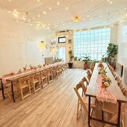 Bat Haus - Sunlit Bat Haus setup with long wooden tables, soft pink runners, florals, and warm lights--perfect for baby showers