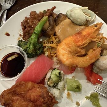Royal Buffet - Super dry sushi mixed with bland food - A white plate holds sushi, a fried chicken wing, shrimp, broccoli, and other Asian dishes, with soy sauce on the side. - Buffets Near Me - Hoffman Estates, Illinois