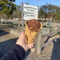 Waffle cone with jimmies in front of the sign. Waffle cone with jimmies in front of the sign.
