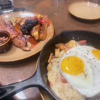 Proximo - garbage skillet has potatoes mixed with peppers along with sausage gravy and topped with two over easy eggs - Spanish Near Me - Fort Wayne, Indiana