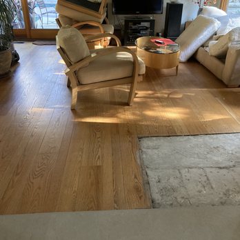 Pablo's Hardwood Floors - Before - wood planks were dull, uneven color. Concrete fireplace heath sub-floor on right. - Flooring Near Me Pablo's Hardwood Floors - Before - wood planks were dull, uneven color. Concrete fireplace heath sub-floor on right. - Flooring Near Me