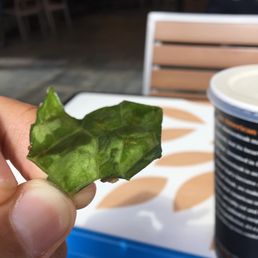a hand holding a piece of lettuce