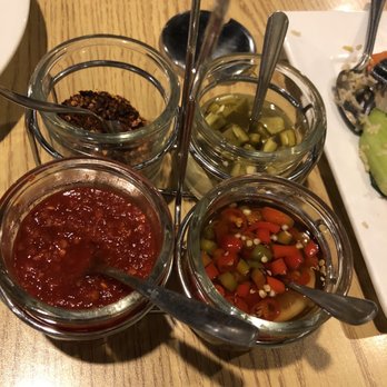 Sawasdee Thai Cuisine - To spice up a dish: (Clockwise) jalapeños, peppers in fish sauce, chili paste/sauce, crushed red peppers. - Thai Near Me - Overland Park, Kansas