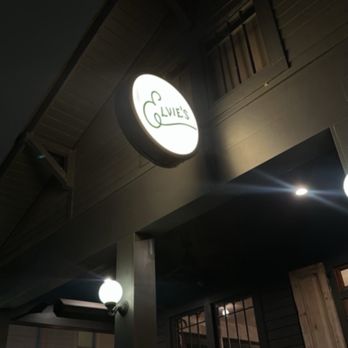 Elvie’s - Outdoor entrance - Nighttime view of Olive's restaurant exterior featuring illuminated sign, outdoor seating area, and building details. - Breakfast & Brunch Near Me - Jackson, Mississippi
