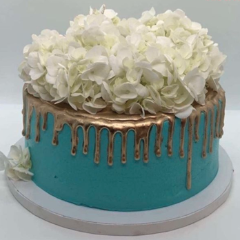 Rhapsody’s Tasties - a blue cake with white flowers - Desserts Near Me Rhapsody’s Tasties - a blue cake with white flowers - Desserts Near Me
