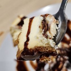Pollard 107 South - Close-up of a spoonful of the Cheesecake with chocolate syrup.