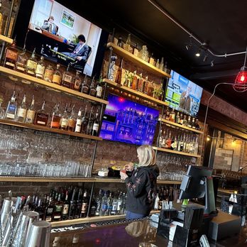Next Door - a woman at a bar with a television in the background - Beer, Wine & Spirits Near Me - Dayton, Ohio