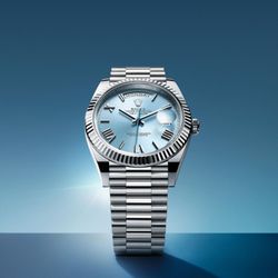 Razny - Rolex: The platinum Day-Date 40 featuring an ice-blue dial with faceted Roman numerals, fluted bezel, and fitted with the President bracelet