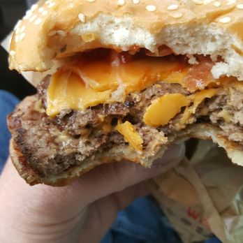 Burger King - a hand holding a hamburger with cheese and lettuce - Burgers Near Me - Spanish Fork, Utah