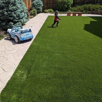 Synthetic turf & landscape - Granddaughter enjoying the new turf. - Landscaping Near Me Synthetic turf & landscape - Granddaughter enjoying the new turf. - Landscaping Near Me