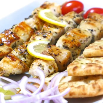 Sakis - a plate of chicken skewers with onions and tomatoes - Mediterranean Near Me - Burlington, Ontario