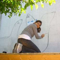 Hubbard Street Murals - Artist Carolina Blanco working on the drawing of her mural depincting a group of Seals, at The Hubbard Street Murals in Chicago