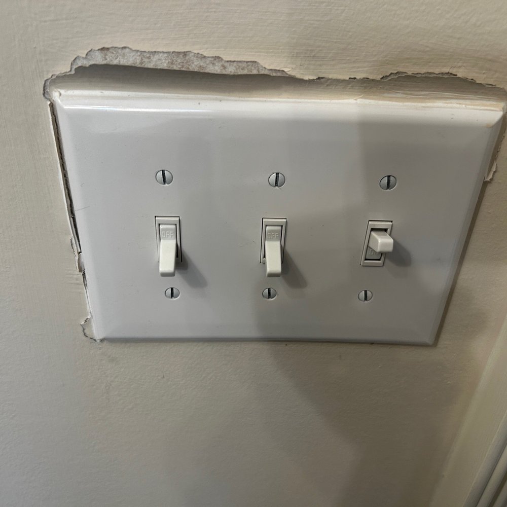 They caulked around the light switches so when they had to fix faulty wiring, this happens.