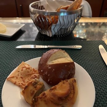 Polo Lounge - Bread basket contents (pretzel roll, parmesan crisp, and a slice & a 1/2 of an interesting bread with blue cheese, plated) - New American Near Me - Beverly Hills, California