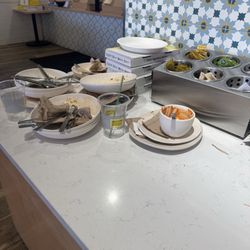 There were so many dishes in the bin they had to be placed on the countertop.